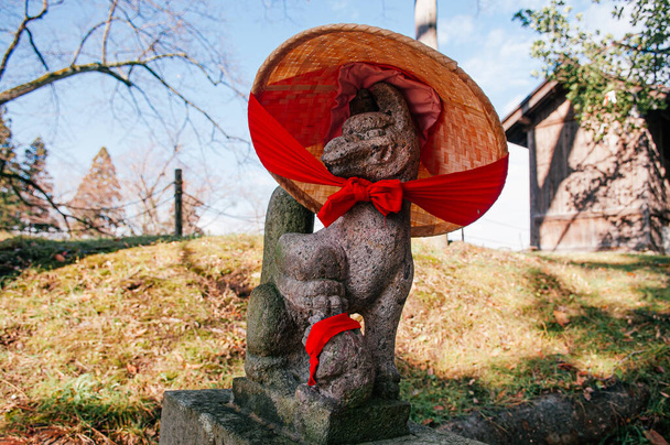 Kitsune estatua de piedra de zorro japonés con la escasez de rojo y sombrero en el santuario del castillo de Aizu Wakamatsu Tsuruga - Detalles de cerca de la cara - Japón dios guardia zorro
 - Foto, Imagen