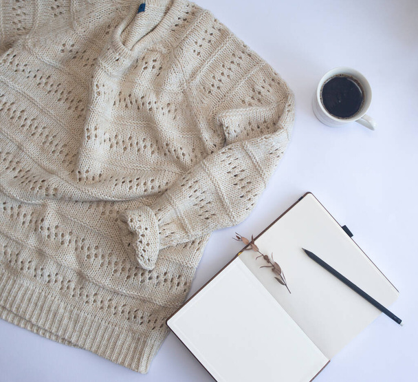 warm knitted wool sweater winter mock up with objects notepad pencil and cup of coffee - Fotografie, Obrázek