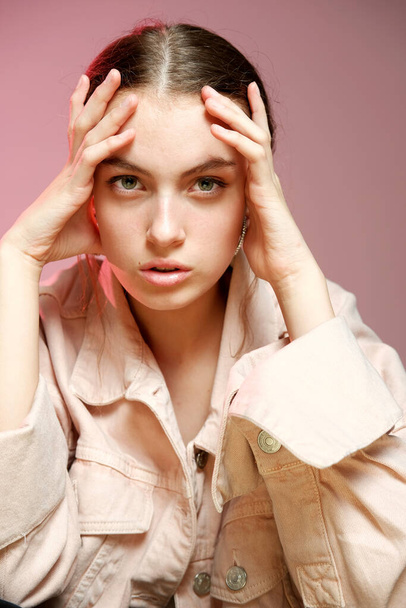 A girl in a pink denim shows different emotions and poses on a pink background. - Foto, Imagem