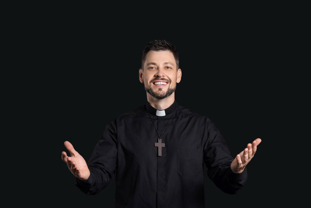 Handsome priest on dark background - Photo, Image