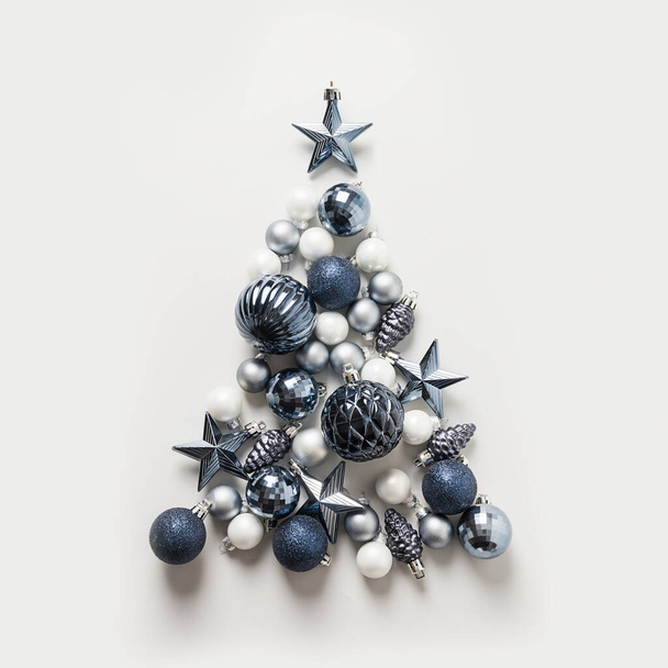 Christmas tree made of stars, blue balls on grey background. Xmas composition. Holiday Greeting card. Happy New Year. - Fotografie, Obrázek