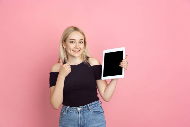 Portrait of young caucasian woman with bright emotions on coral pink studio background - Photo, Image