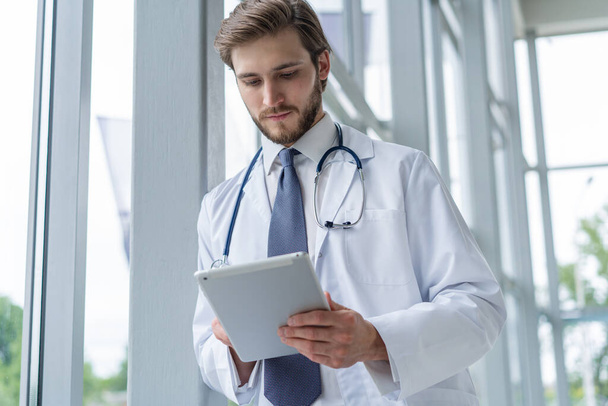 male medical doctor using tablet computer in hospital. - Zdjęcie, obraz