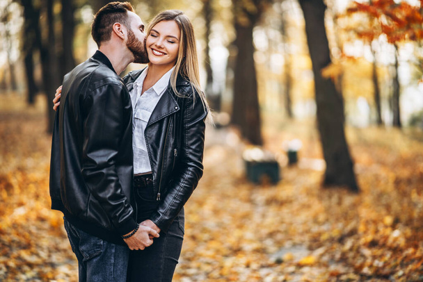 Portrait of a young loving couple. Man and woman hugging and smiling in the background of autumn park. - Fotoğraf, Görsel