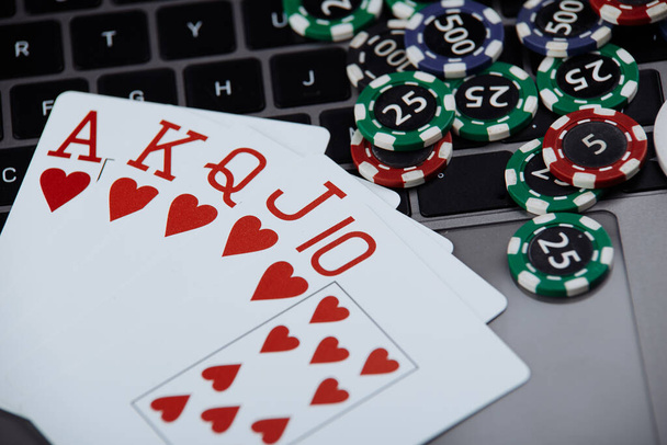 Tarjetas de póquer y pilas de fichas de póquer en una computadora portátil. Poker concepto en línea
 - Foto, imagen