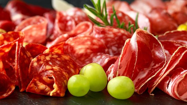 Conjunto de Salame, chouriço, coppa, lomo, carne bovina, bandeja de carne antipasto em placa de pedra
 - Foto, Imagem