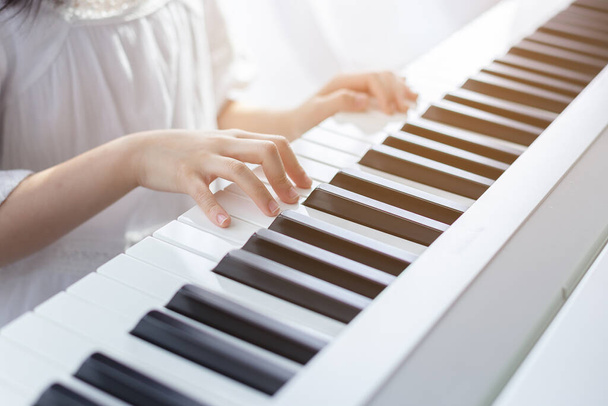 азіатська красива дівчина грає на електричному піаніно у вітальні вдома
. - Фото, зображення