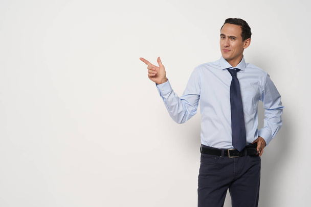 Ένας άνδρας με ένα κλασικό κοστούμι δείχνει ένα δάχτυλο στο πλάι του γραφείου εργασίας των επιχειρήσεων ελεύθερο χώρο - Φωτογραφία, εικόνα