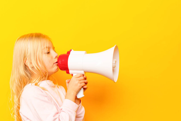 Kid shouting through vintage megaphone. Communication concept. Blue sky background as copy space for your text - Photo, Image