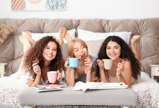 Mooie jonge vrouwen tijdens pyjamafeest thuis - Foto, afbeelding