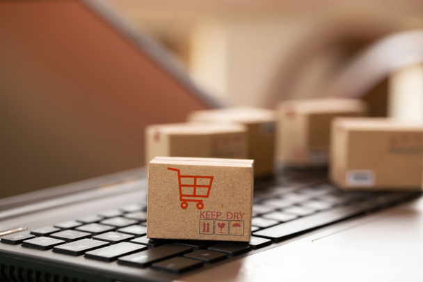 Zakupy online, koncepcja e-commerce: Pudełka kartonowe na klawiaturze. przedstawia transport, który można łatwo wykonać za pomocą internetu online. - Zdjęcie, obraz
