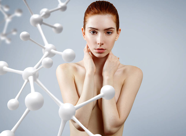 Young woman covering her breasts among molecules chain. - Photo, Image