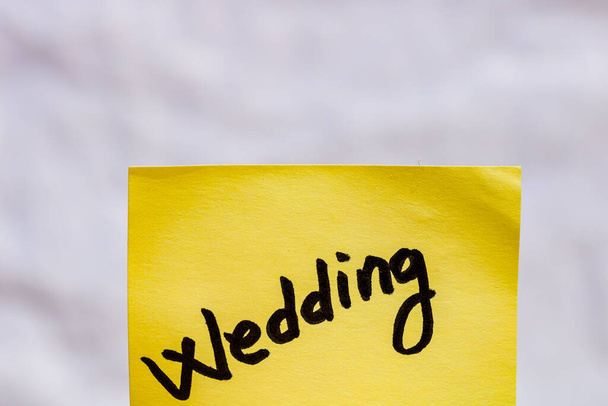 Wedding handwriting text close up isolated on yellow paper with copy space. - Photo, Image