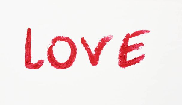 liefde geschreven in rode lippenstift op een wit papier, datum concept, close-up - Foto, afbeelding