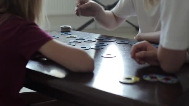 Zbliżenie gry planszowej Pamięć, w której rodzice bawią się z córką z kolei przewracając karty z rysunkami - Materiał filmowy, wideo