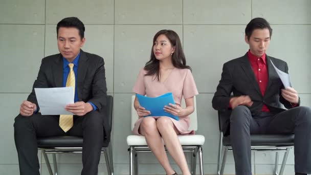 Aasialaiset mies- ja naismyyjät odottavat haastattelun olevan ahdistunut, he näyttävät stressaantuneilta ja levottomilta, koska he tarvitsevat työpaikan avoimessa työpaikassa.. - Materiaali, video