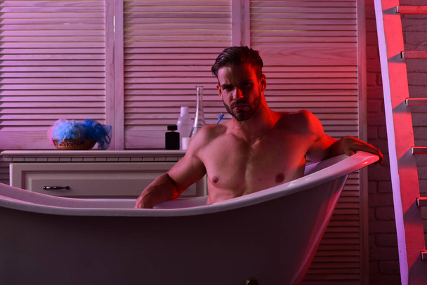 Macho sitting naked in bathtub with seductive look - Fotoğraf, Görsel