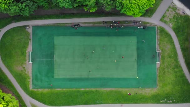 Vista aérea de hombres jugando al fútbol en un campo de fútbol público de la ciudad
 - Metraje, vídeo