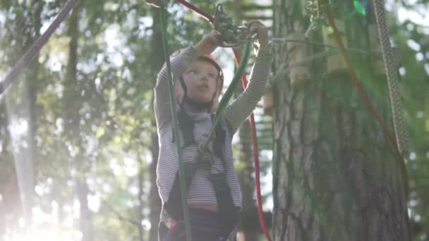 Маленька дівчинка переміщує карабін на мотузці в мотузковому парку
 - Кадри, відео