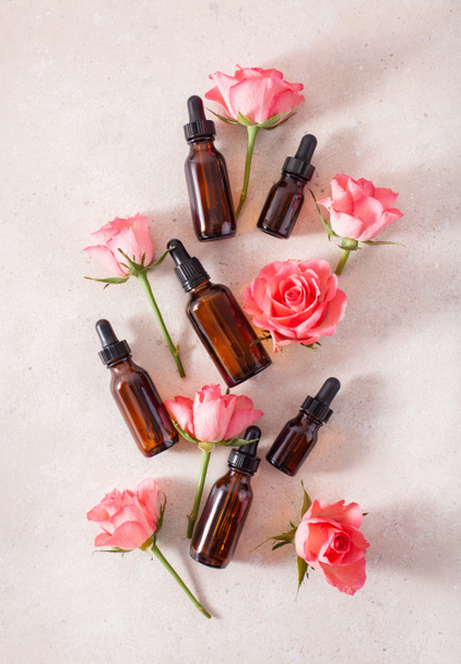 эфирные масла в бутылках розовые цветы. ароматерапия альтернативной медицины - Фото, изображение