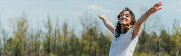 horizontal crop of cheerful woman with outstretched hands smiling outside - Photo, Image
