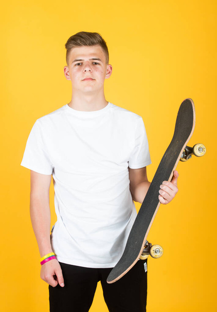 teen boy with skateboard. hipster teen boy hold penny board. urban boy with penny skateboard. young kid has riding hobby. city style. child learns to ride penny board. trendy teen skater practicing - Photo, Image