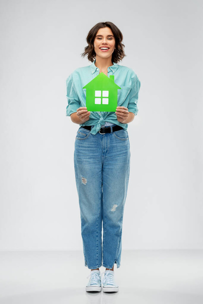 smiling young woman holding green house - Foto, Imagen