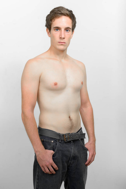 Studio shot of young handsome man shirtless against white background - Photo, Image