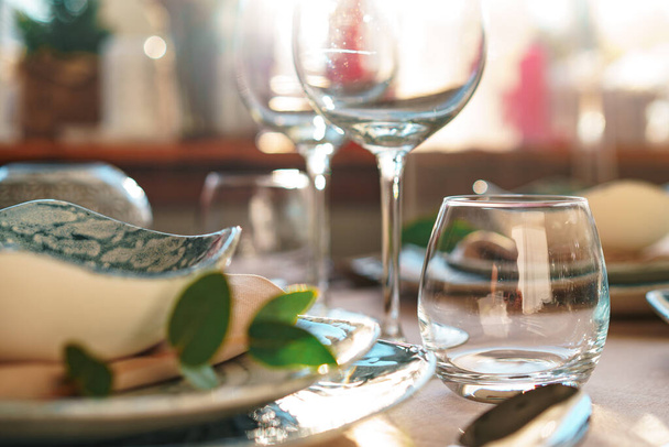 Beautiful elegant table setting with green stylish dishware and silver cutlery - Фото, зображення
