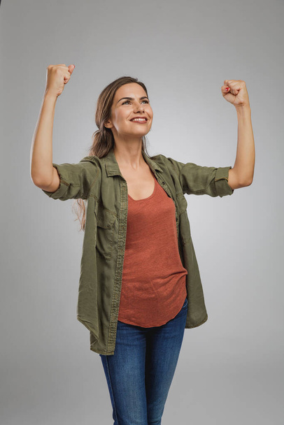 Beautiful and successful young woman with arms raised - Foto, imagen