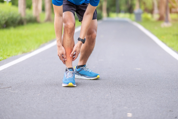 Молодий дорослий чоловік з болем м'язів під час бігу. Бігун має біль у ногах через Шінь Сплінт. Поранення від спорту та медична концепція - Фото, зображення