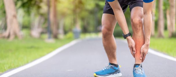 Jonge volwassen man met spierpijn tijdens het hardlopen. Runner man heeft pijn aan zijn benen door Shin Splints. Sportblessures en medisch concept - Foto, afbeelding