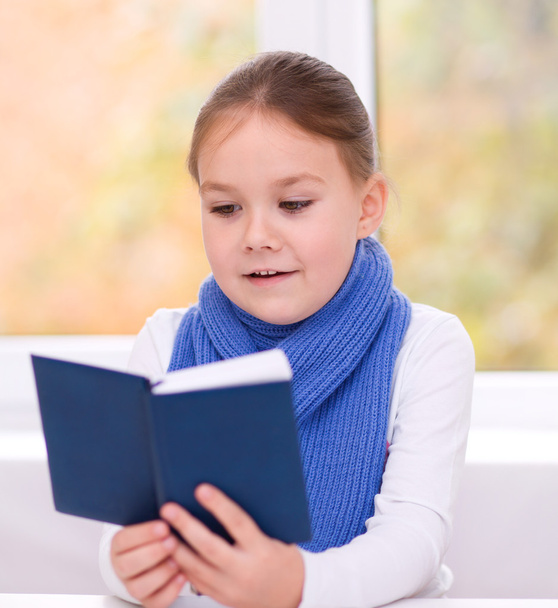 маленька дівчинка читає книжку
 - Фото, зображення