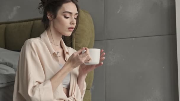Young beautiful amazing woman indoors at home drinking coffee - Záběry, video