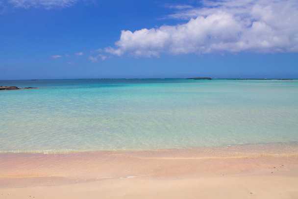 Pláž s růžovým pískem a tyrkysovou vodou a mraky na modré obloze. - Fotografie, Obrázek