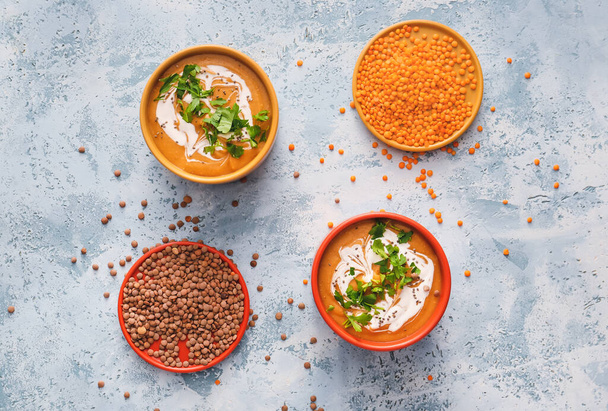 Ciotole di gustosa zuppa di lenticchie su sfondo di colore - Foto, immagini