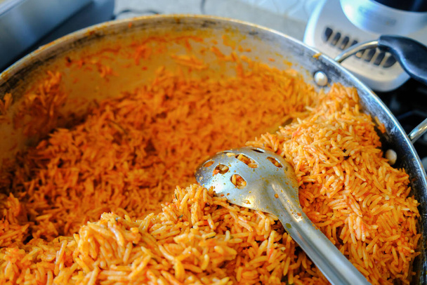 Potje Nigeriaanse Jollof rijst met eetlepel - Foto, afbeelding