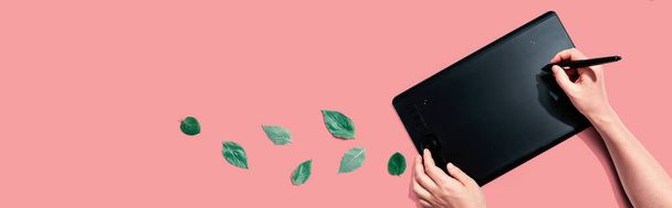 Graphic pen tablet with green leaves - 写真・画像