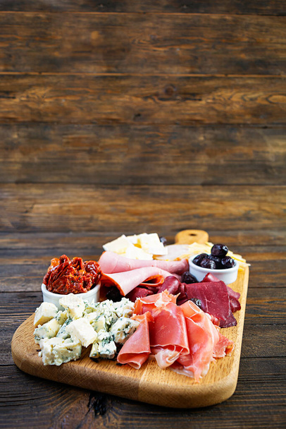 Italian antipasto. Antipasti board with ham, salsami, prosciutto, parmesan, blue cheese and olives. - Photo, Image