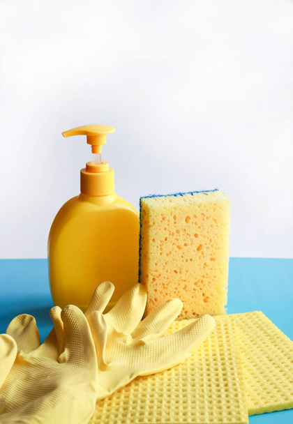 latex gloves, sponge and disinfectant on a blue and white background. hygiene concept - Foto, afbeelding