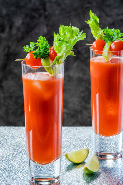 Bloody Mary cocktail with vodka and tomato juice with garnishes - alcoholic party drink - Foto, Imagem