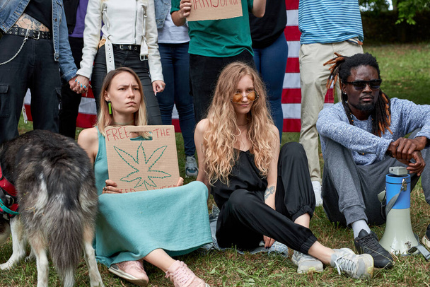 youth holding a sign protesting the laws against marijuana usage - 写真・画像