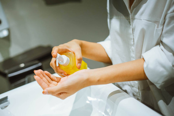 vrouw met behulp van alcohol antiseptische gel om de hand te reinigen - Foto, afbeelding