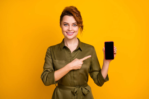 Portrait of her she nice attractive lovely pretty confident cheerful cheery wavy-haired girl demonstrating new digital device advert isolated on bright vivid shine vibrant yellow color background - Фото, зображення