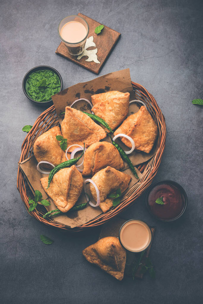 Samosa - Háromszög alakú sült / sült tészta sós töltelékkel, népszerű indiai tea Time snack, zöld chutney, paradicsom ketchup - Fotó, kép