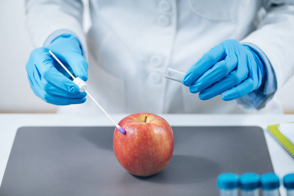 Εργαστηριακή Ανάλυση Ασφάλειας Τροφίμων - Βιοχημικός που αναζητά παρουσία φυτοφαρμάκων σε μήλα  - Φωτογραφία, εικόνα