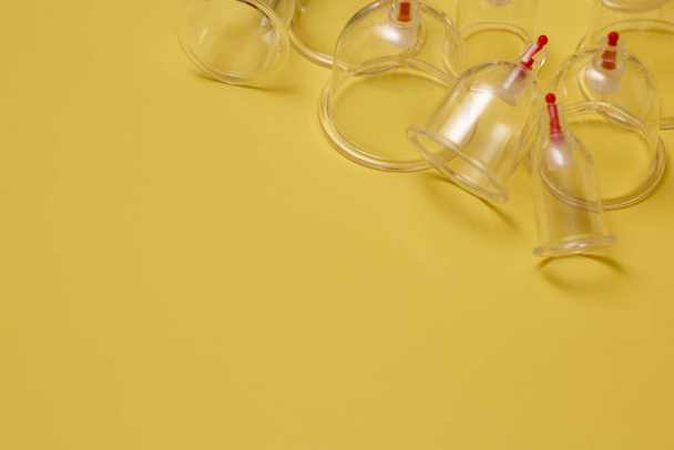 Jars for hijama. Vacuum pumps on a yellow background - Photo, image