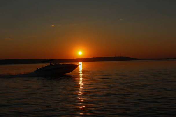 The boat floats on the sea at sunset - Valokuva, kuva