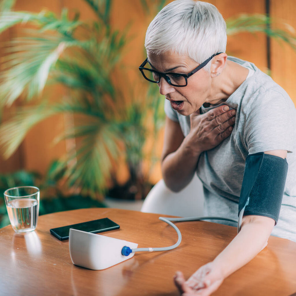 Senior Woman Using Blood Pressure Meter - Fotoğraf, Görsel