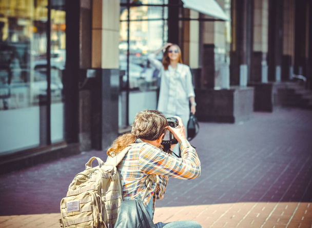 A man with a camera walks around the city photographing the neighborhood. The tourist came to see European sights and take a walk with a good mood - Фото, зображення